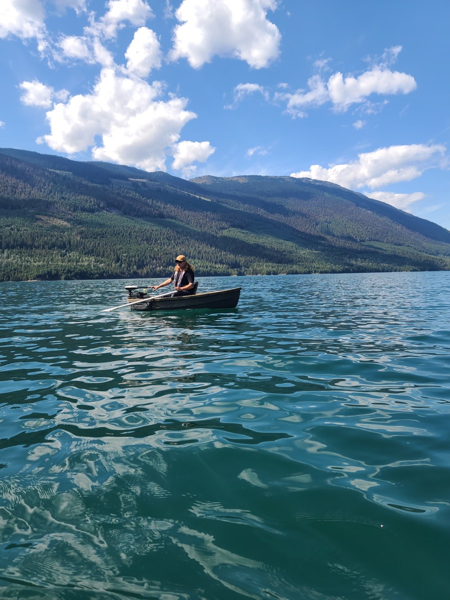 Small boat moving across open stillwater